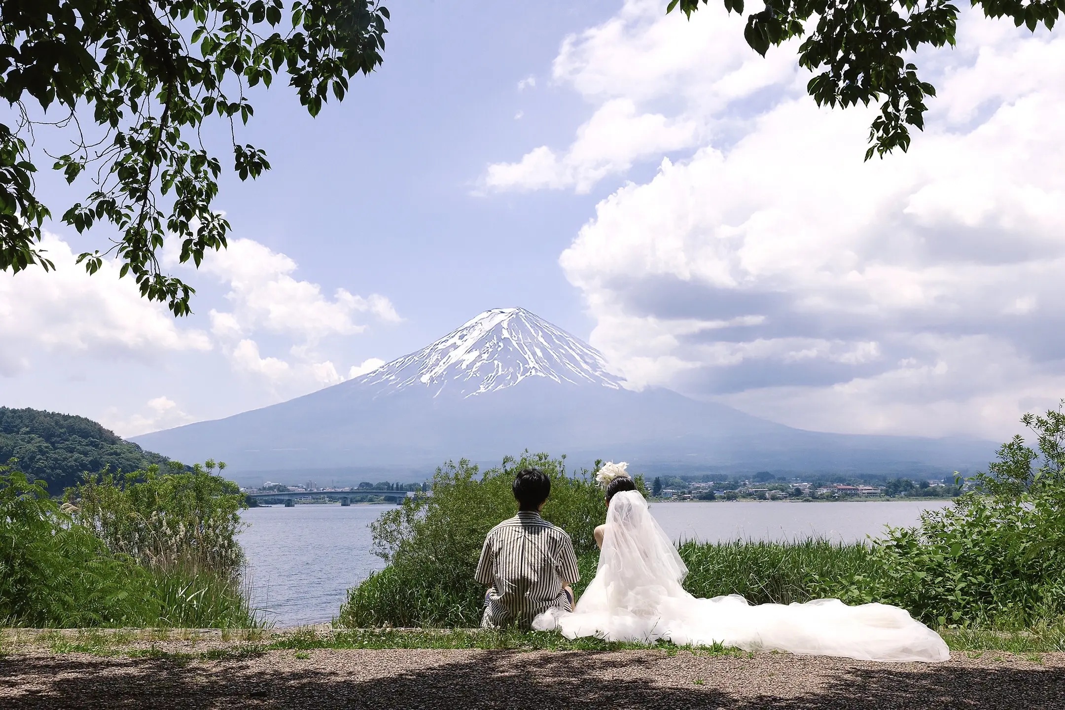 富士山湖边并肩坐着的恋人远景