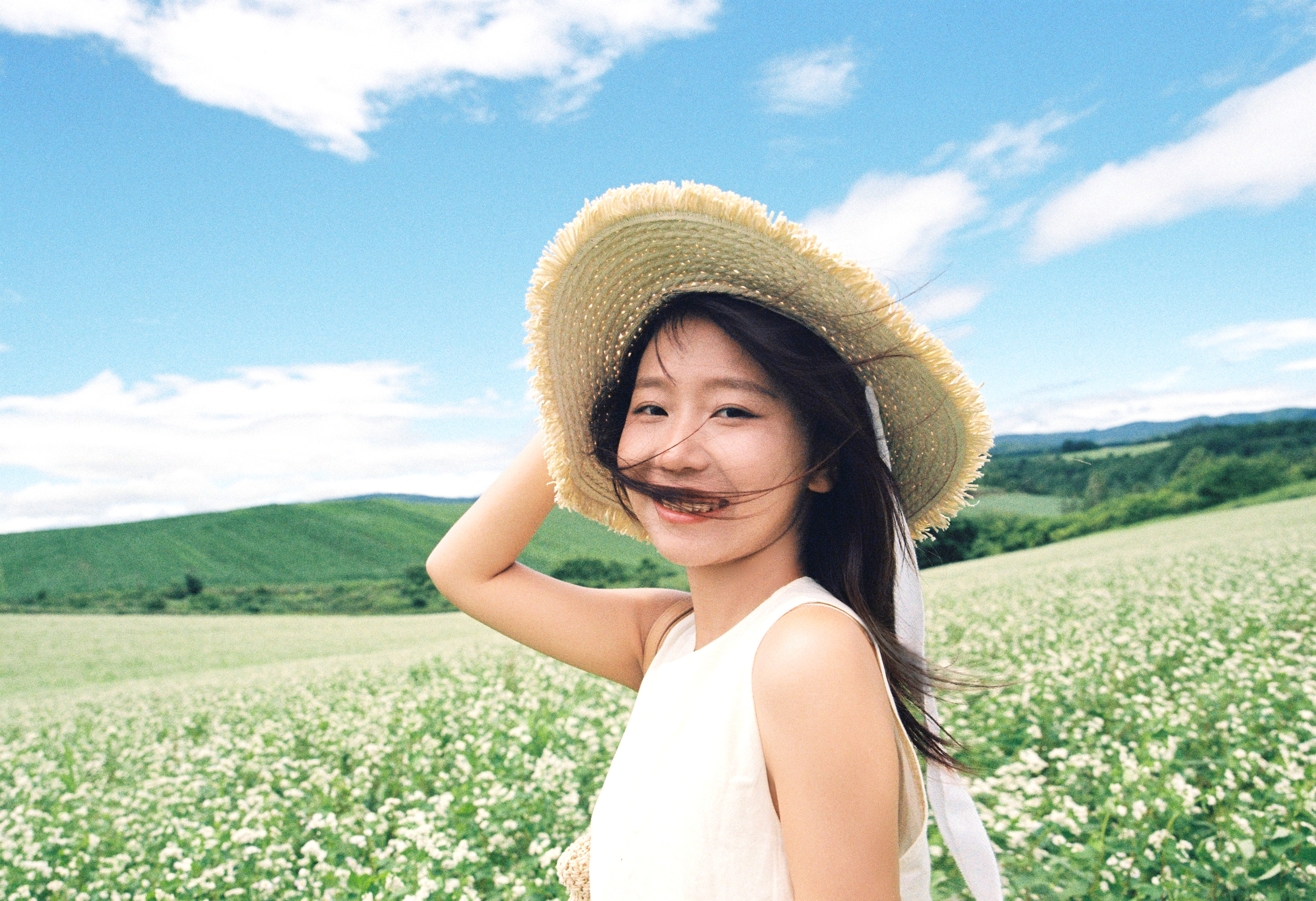 美瑛白花田草帽女生回望