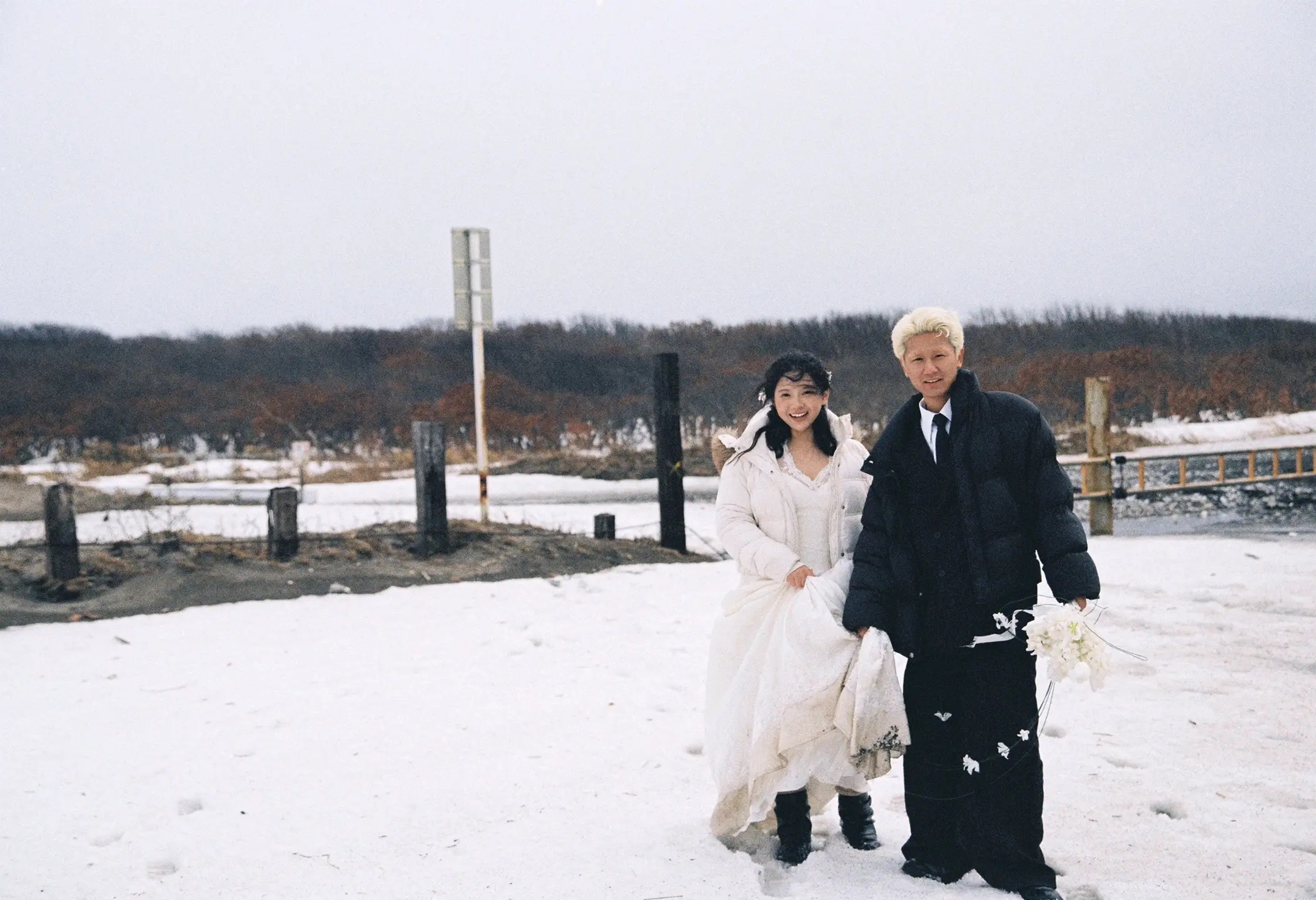 北海道海边雪地中牵手行走的恋人远景