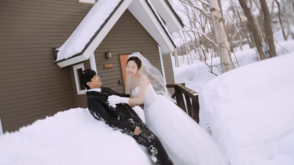 北海道雪坡婚纱照中新娘与新郎自然互动