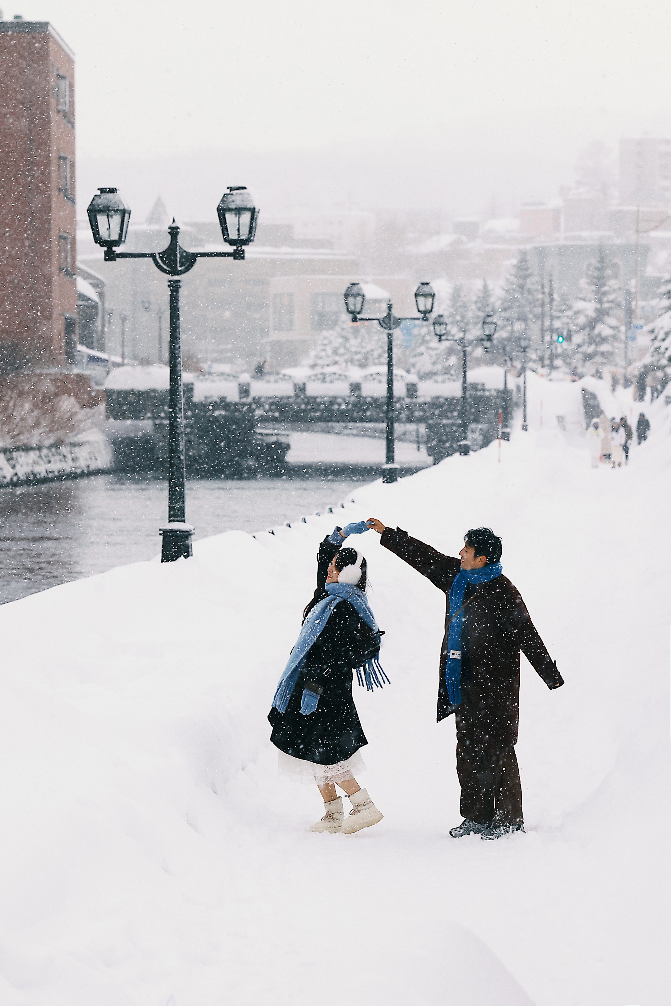 小樽白昼雪地里牵手转身的恋人