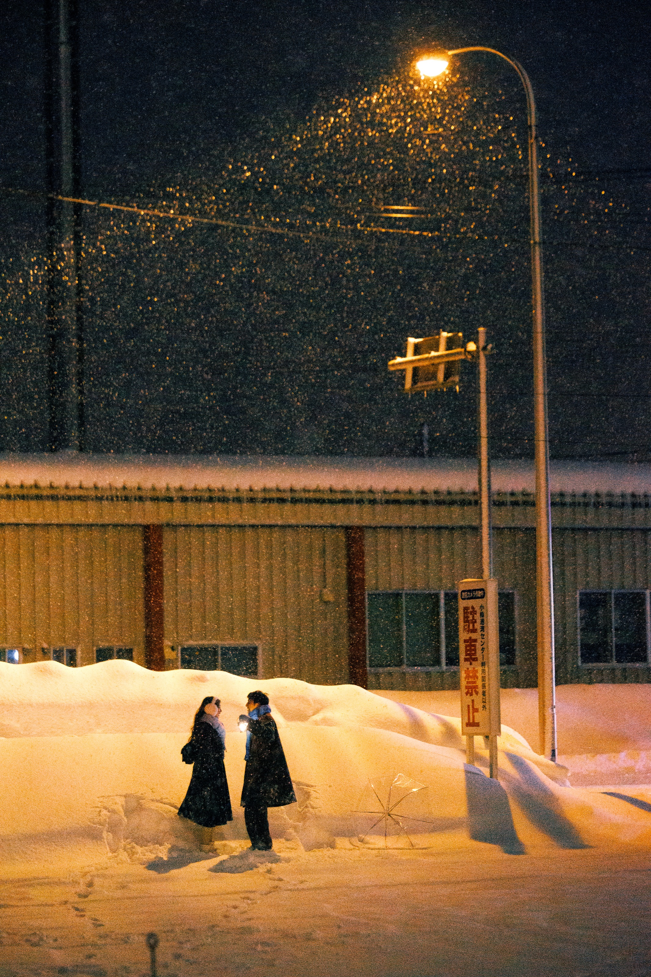 小樽雪夜暖灯下的情侣远景