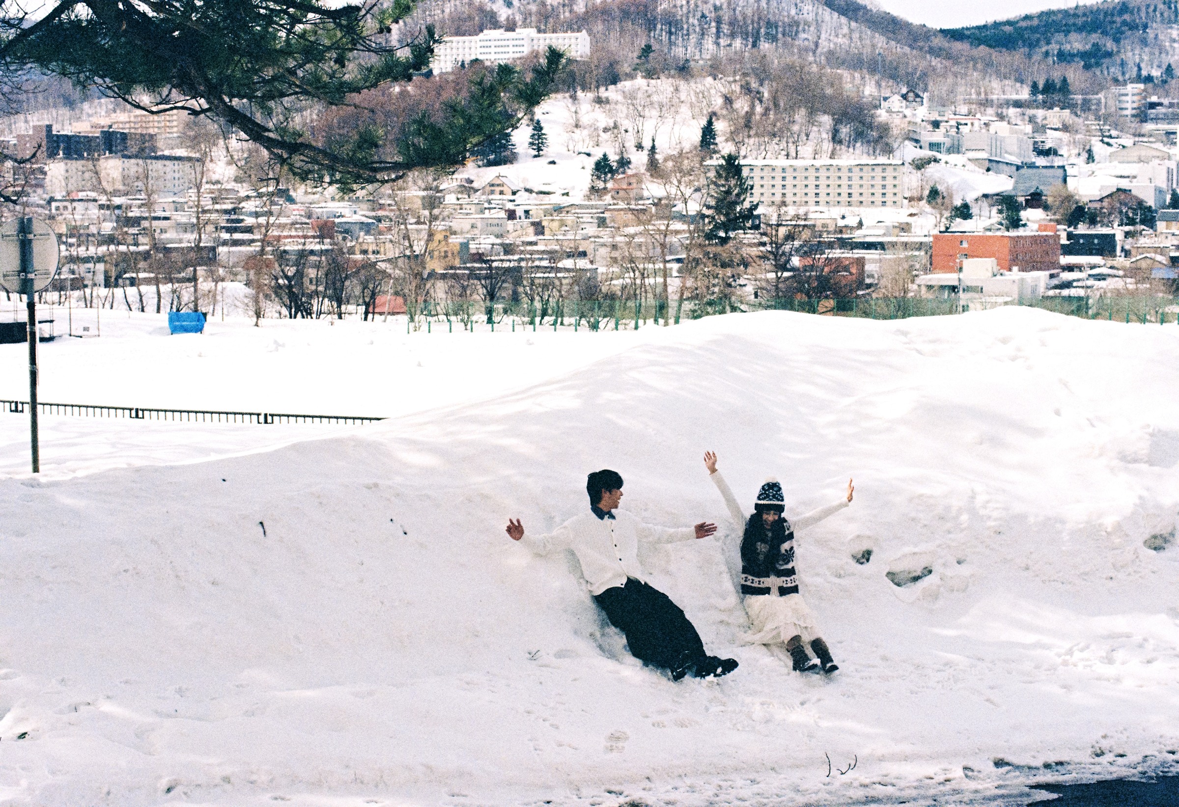 北海道雪坡和城市远景里的两个人