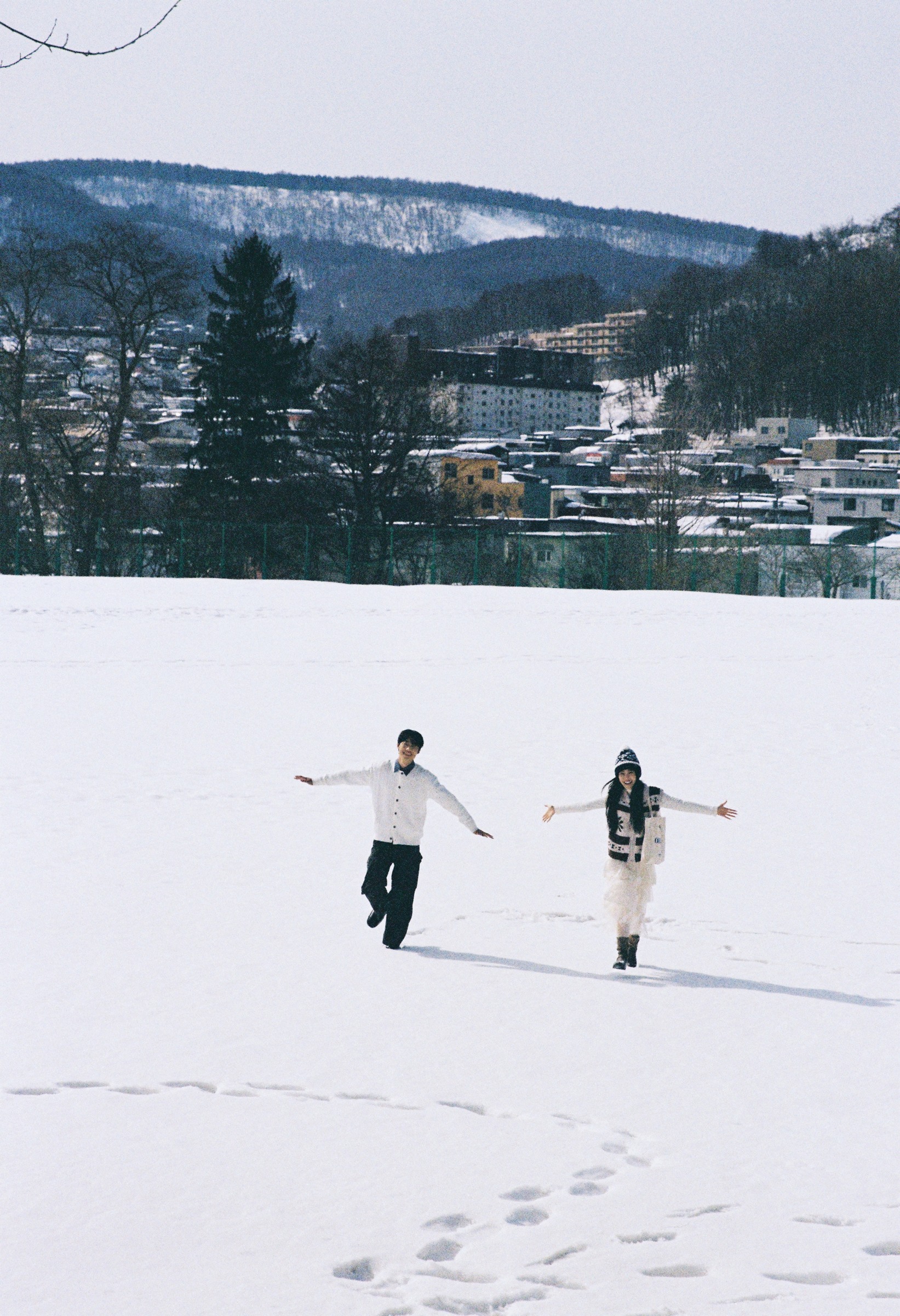 北海道雪原中向远处奔跑的恋人