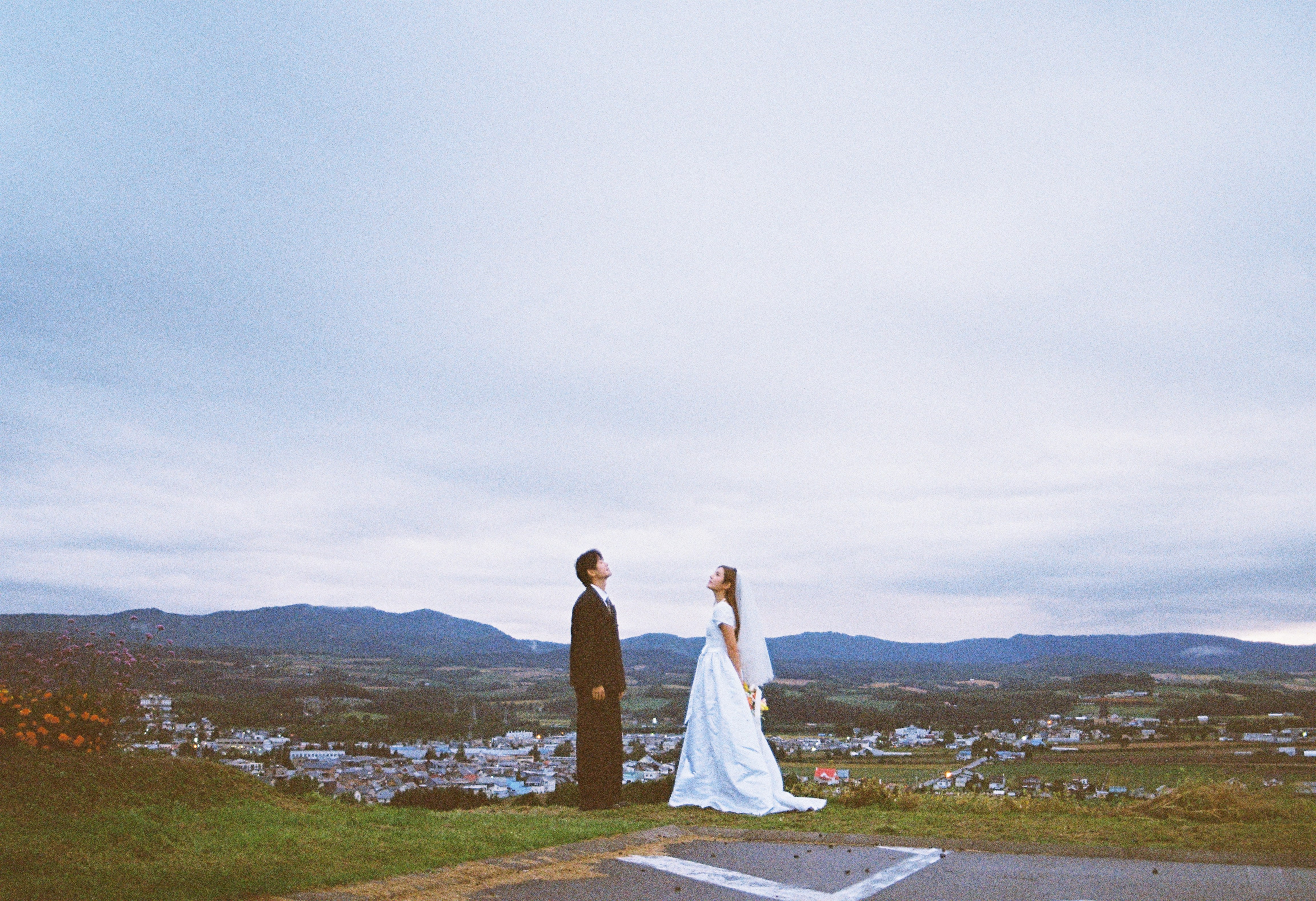 北海道山坡上俯瞰城镇的婚纱远景