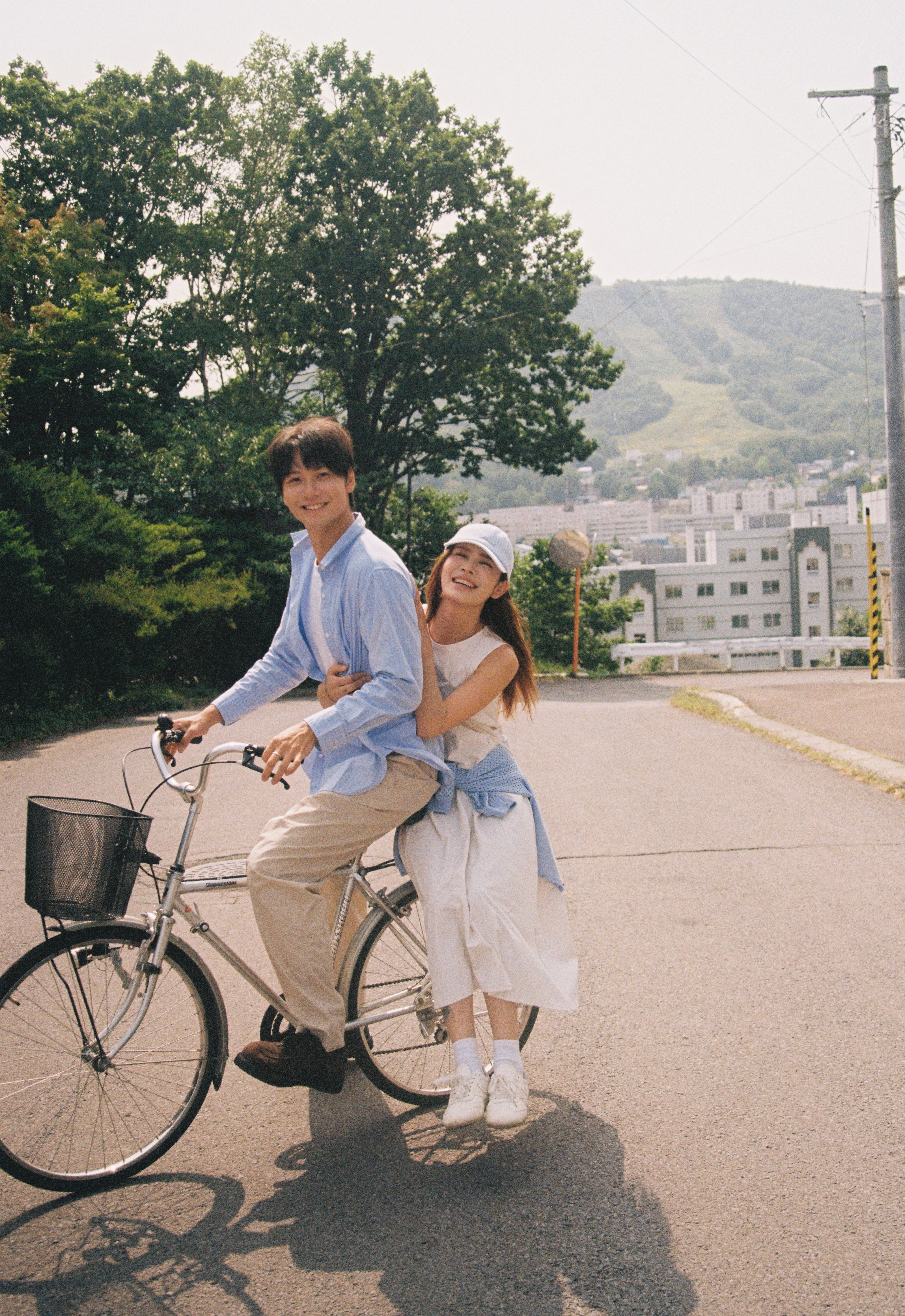 北海道夏天共骑自行车的便服情侣
