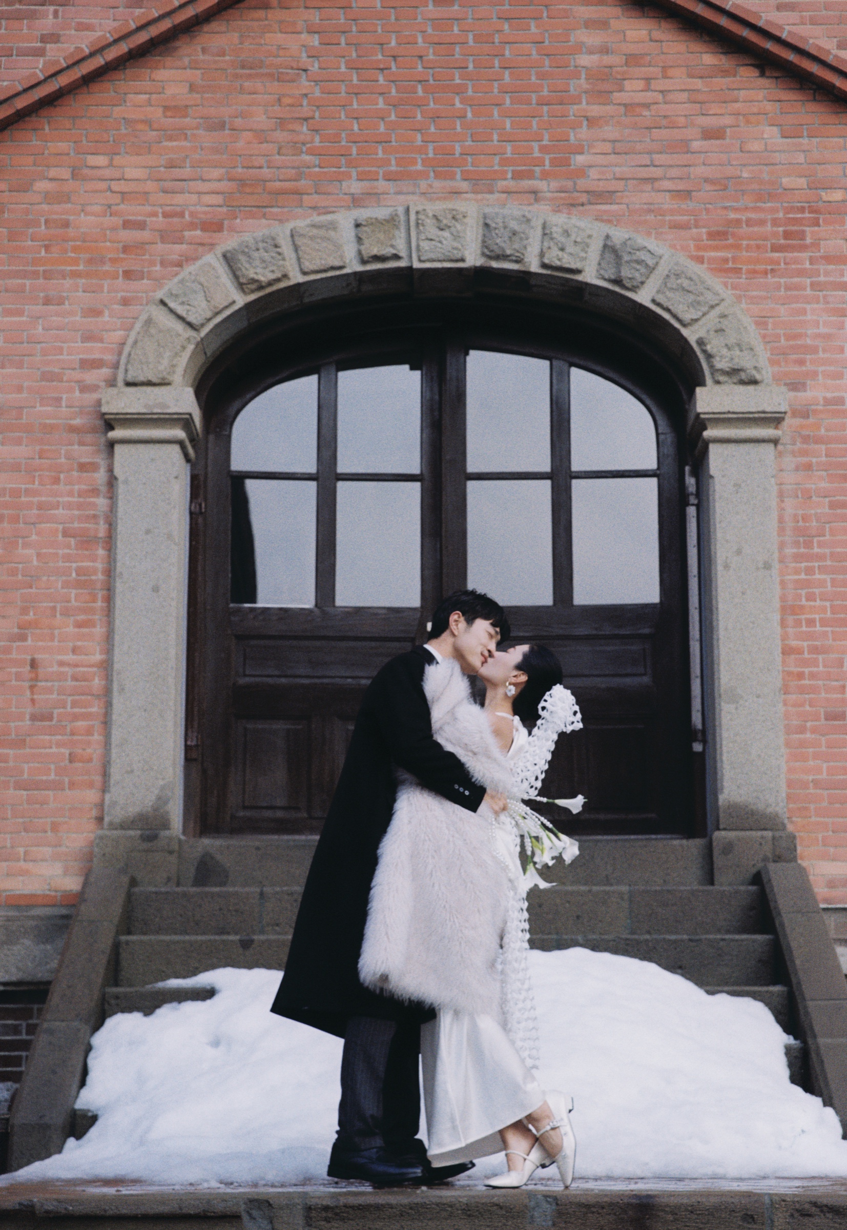 札幌红砖建筑雪地门廊前的婚纱照