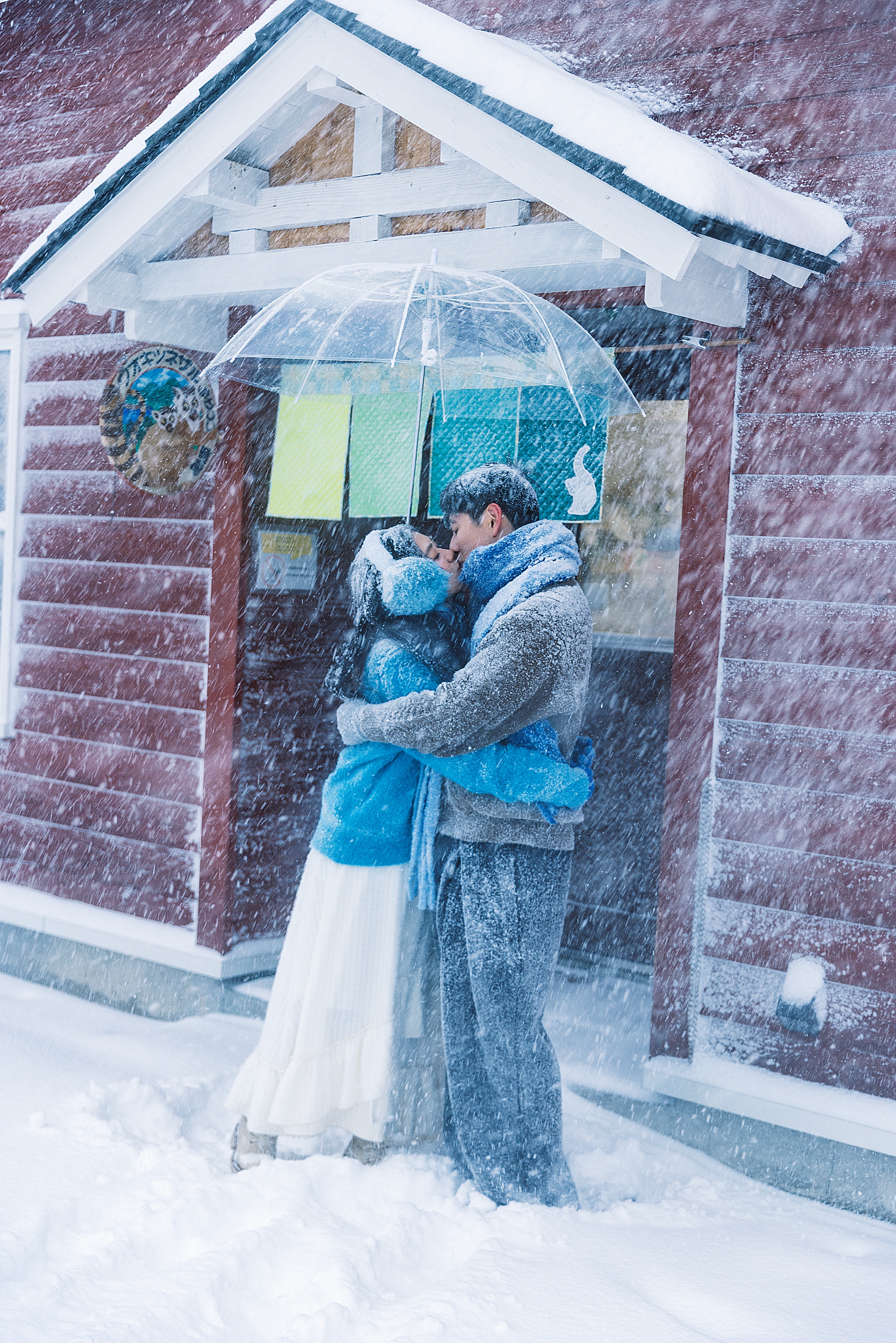 积雪的小店门前，两个人相拥