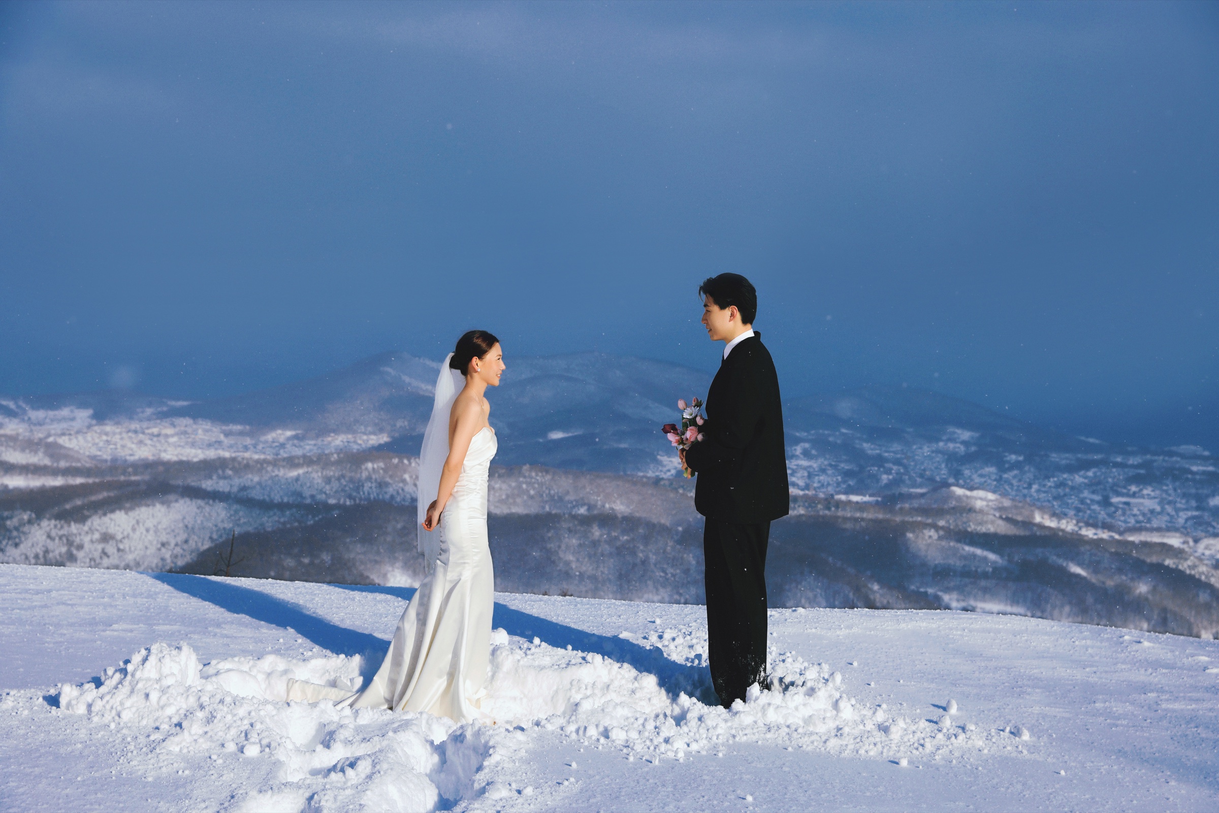 北海道雪山远景中的两人婚纱照